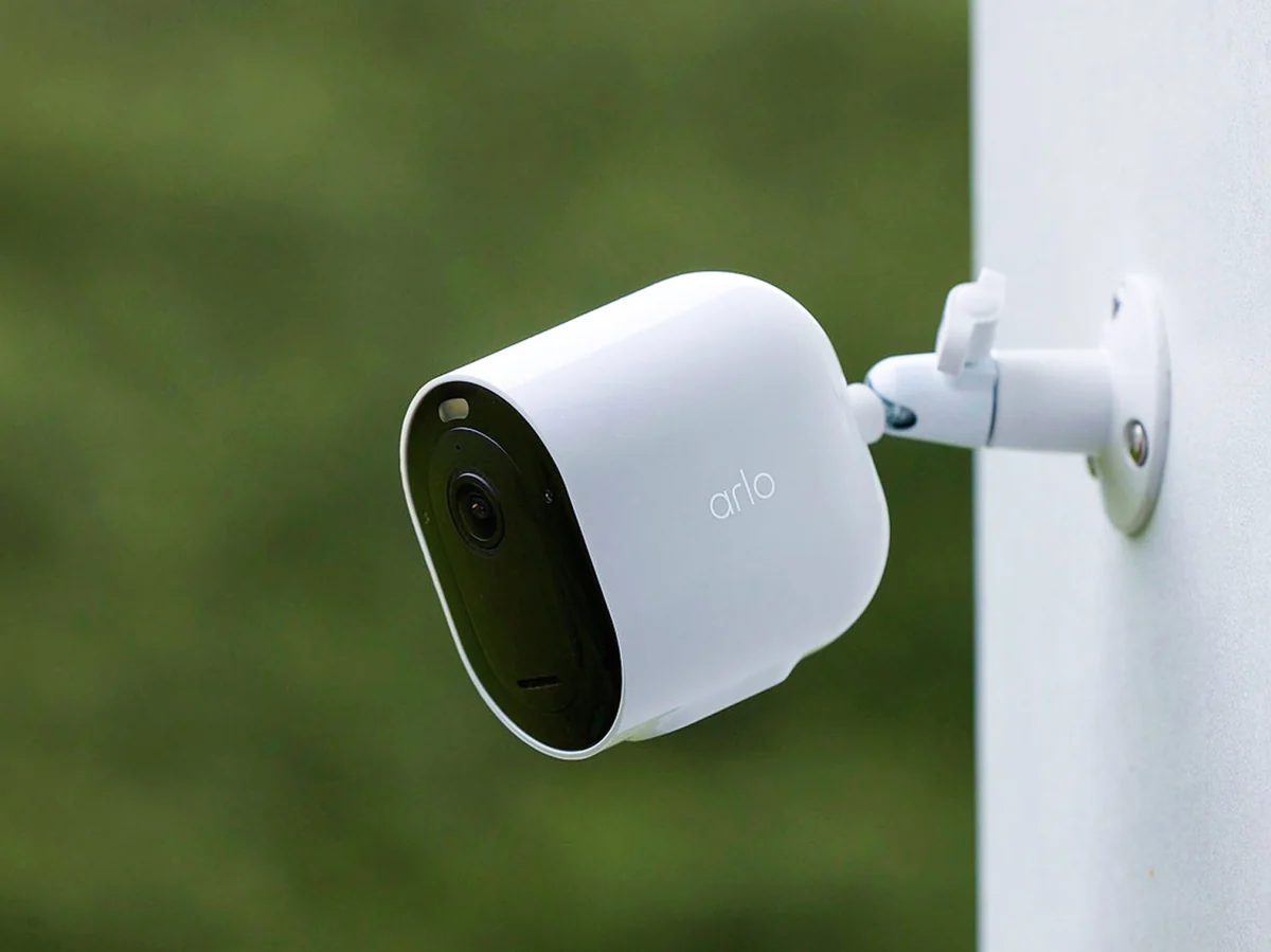 Close-up of the Arlo Pro 6 camera mounted outdoors, showing lens, status LED and Arlo branding