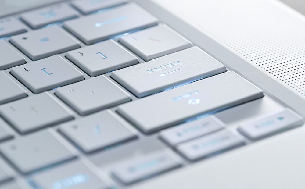 Extreme close-up of the Platinum White ASUS ROG Zephyrus G14 (2024) keyboard, showing the enlarged Enter and Shift keycaps