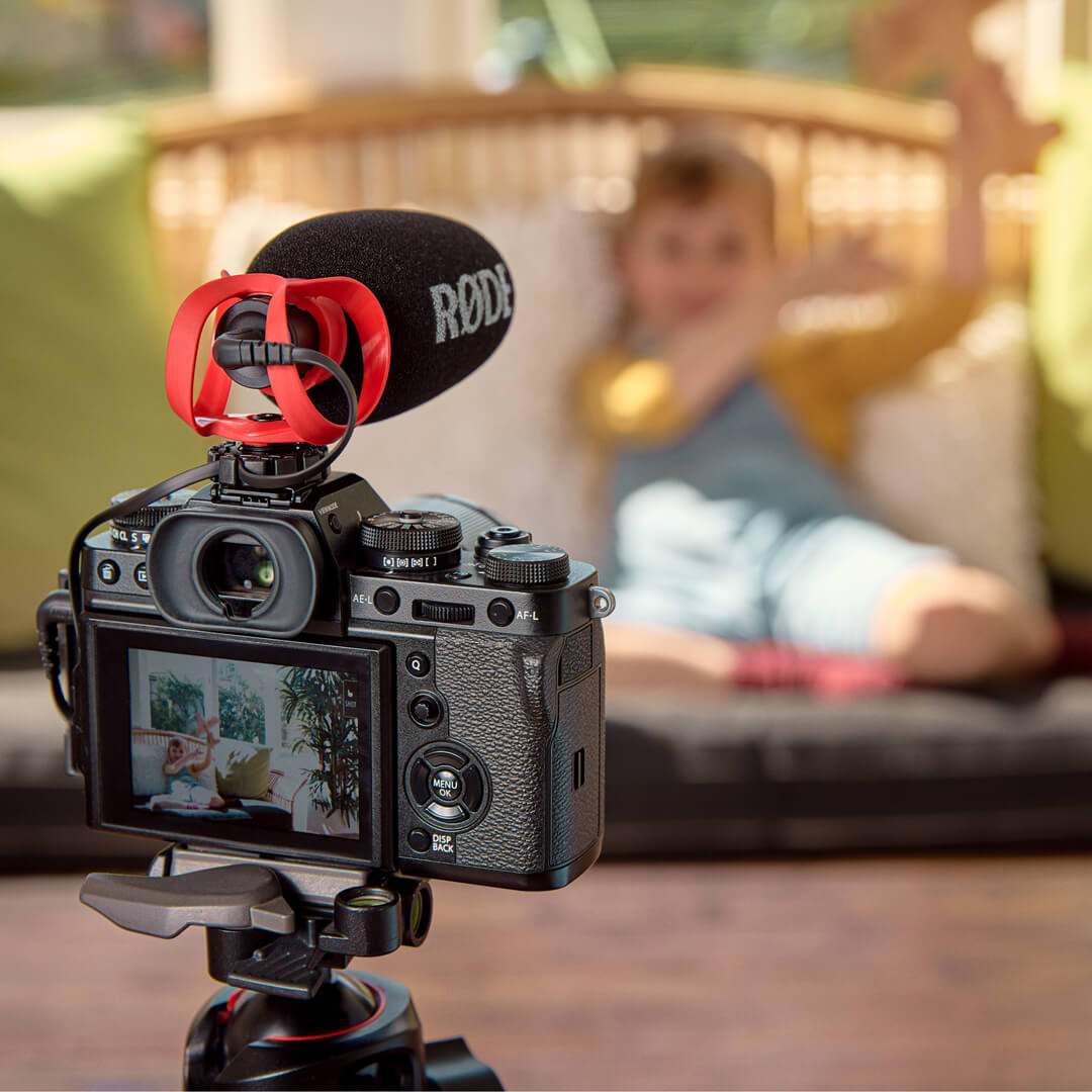 Rear view of a camera with the black VideoMicro II, foam windshield, red HELIX mount and connected audio cable.
