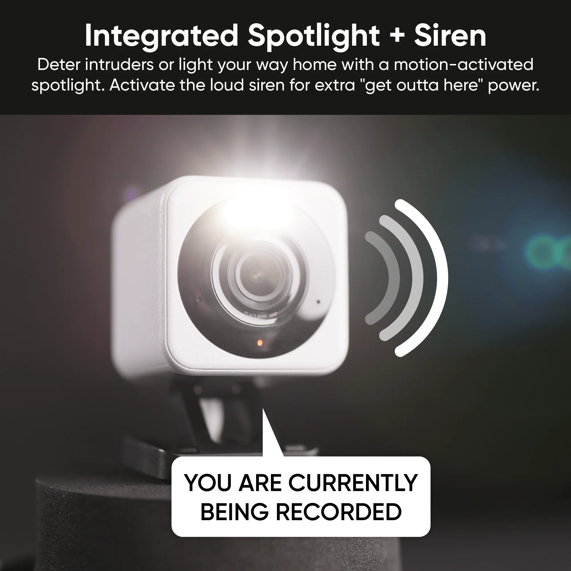 Close-up of the Wyze Cam v4 in white with its integrated spotlight illuminated at night