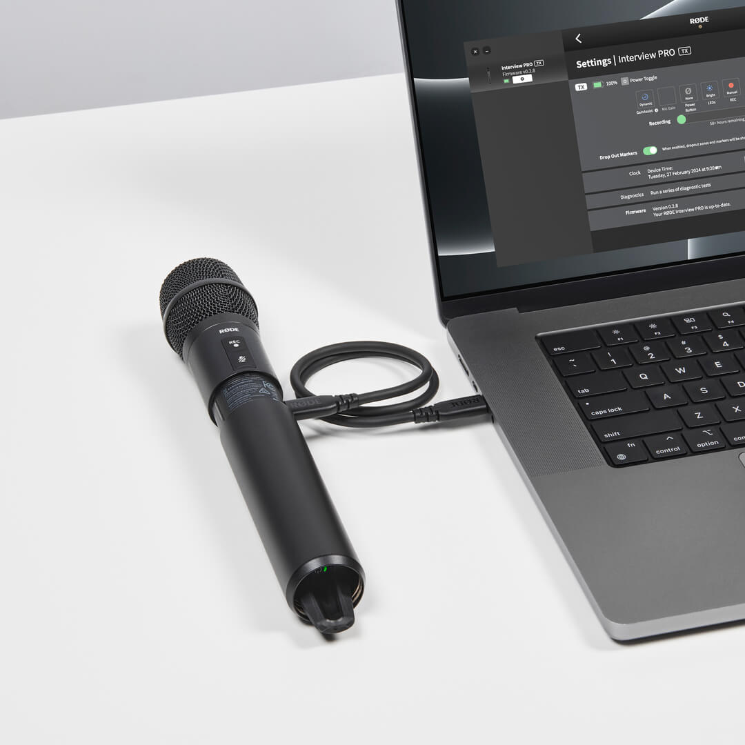 Interview PRO with its lower sleeve opened and a USB-C cable connected to a laptop displaying RØDE Central